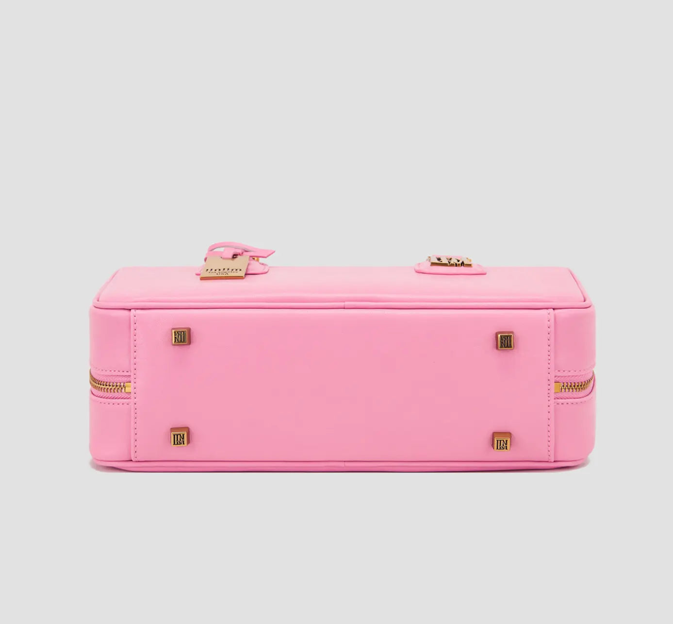 The bottom of pink handbag with gold protective feet and llnllm logo – structured affordable luxury bag from Los Angeles-based brand.