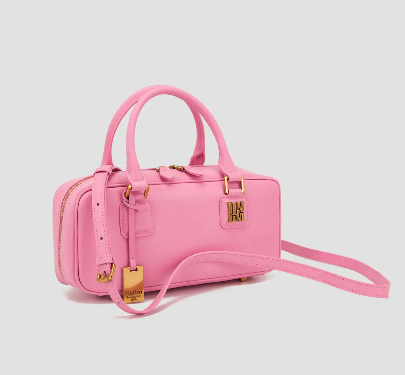 The angled Side View of an affordable luxury pink handbag with a shoulder strap and gold hardware – llnllm women's designer bag from a Los Angeles fashion brand.