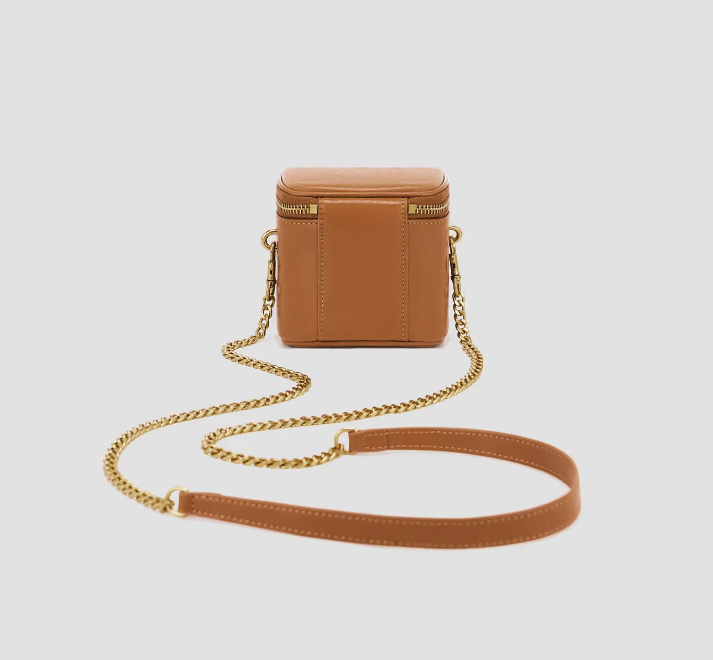 The backside of a tan mini box purse with an adjustable gold chain – casual shoulder bag for modern outfits.