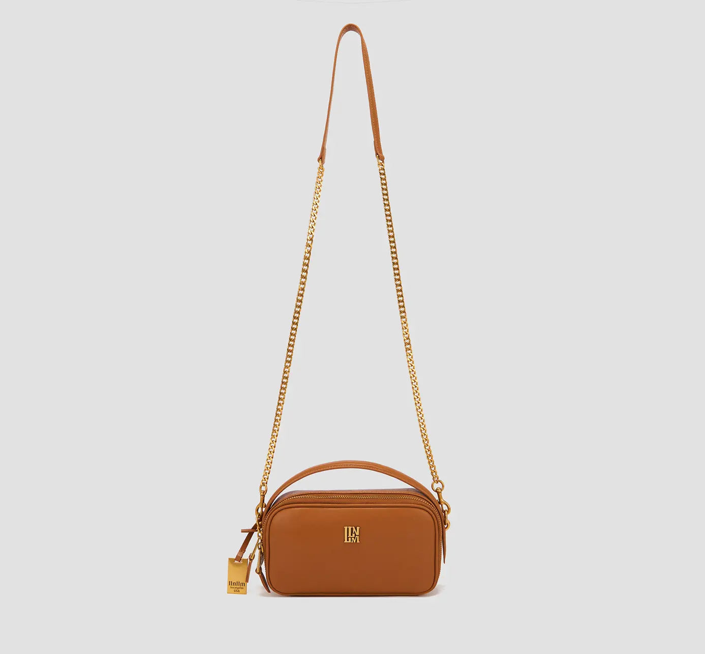 Tan leather rectangular crossbody bag with gold chain strap – designer handbag for women, top handle purse with adjustable strap.
