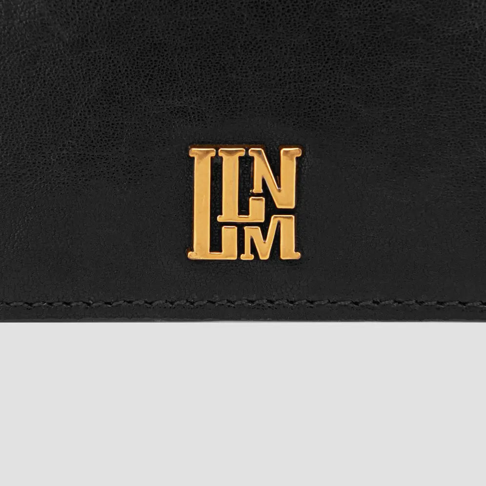 Close-up of llnllm gold logo detail on black slim leather card holder.