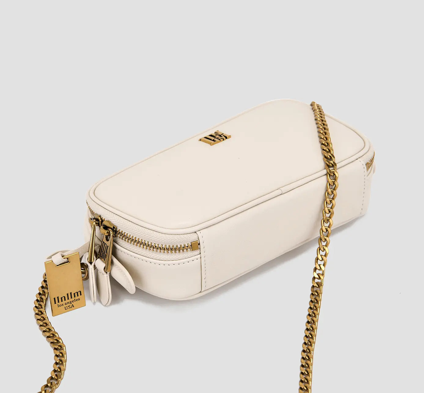 Luxury white mini shoulder bag with dual zipper pulls and gold-tone accents – stylish women’s leather purse.