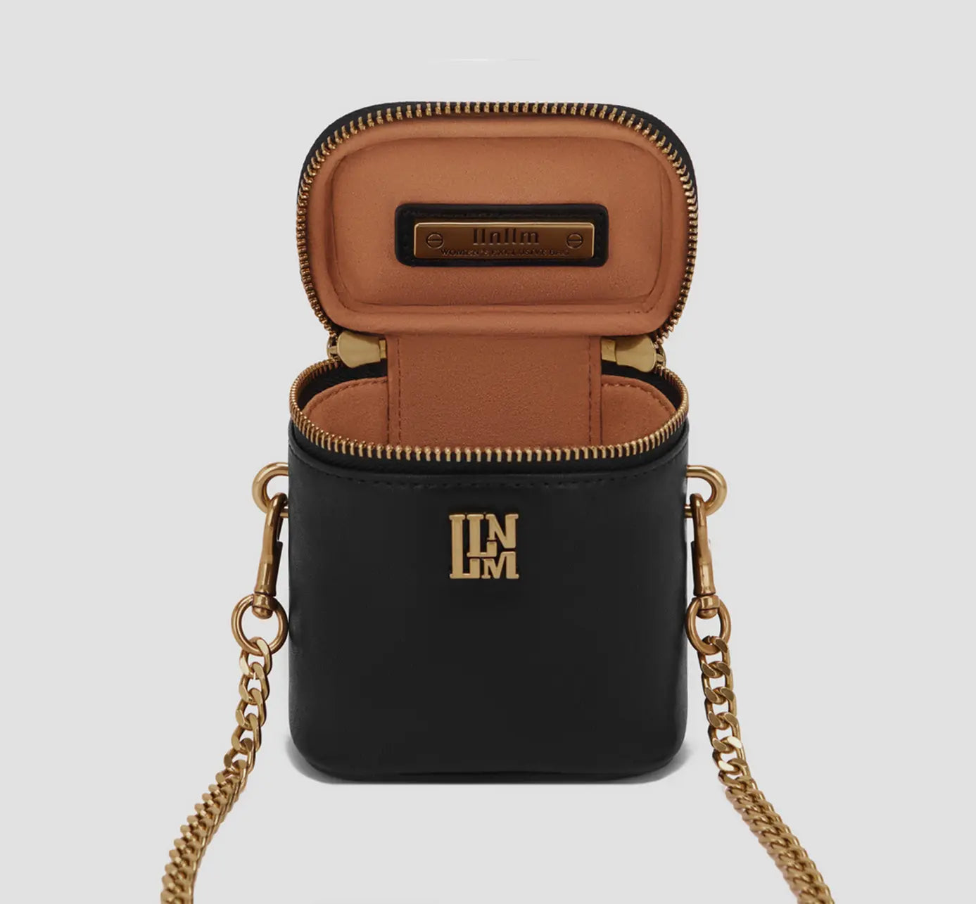 The Interior view of compact black micro bag with tan lining and top-zip closure, small affordable luxury crossbody.
