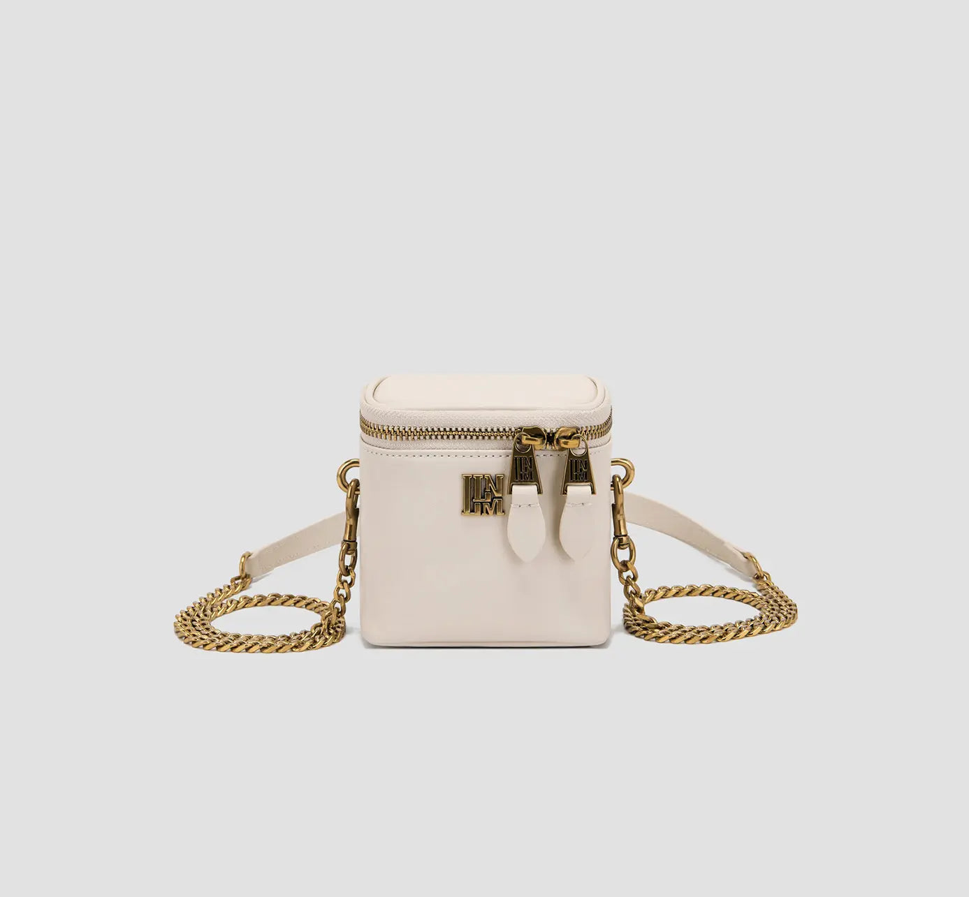 This is the front view of a white mini box purse with a gold zipper and chain strap, a compact crossbody bag for women.
