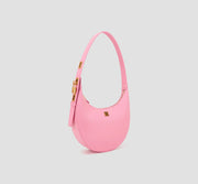 The angled front of chic crescent pink handbag with adjustable strap – elegant and minimalist leather bag for casual or evening wear.
