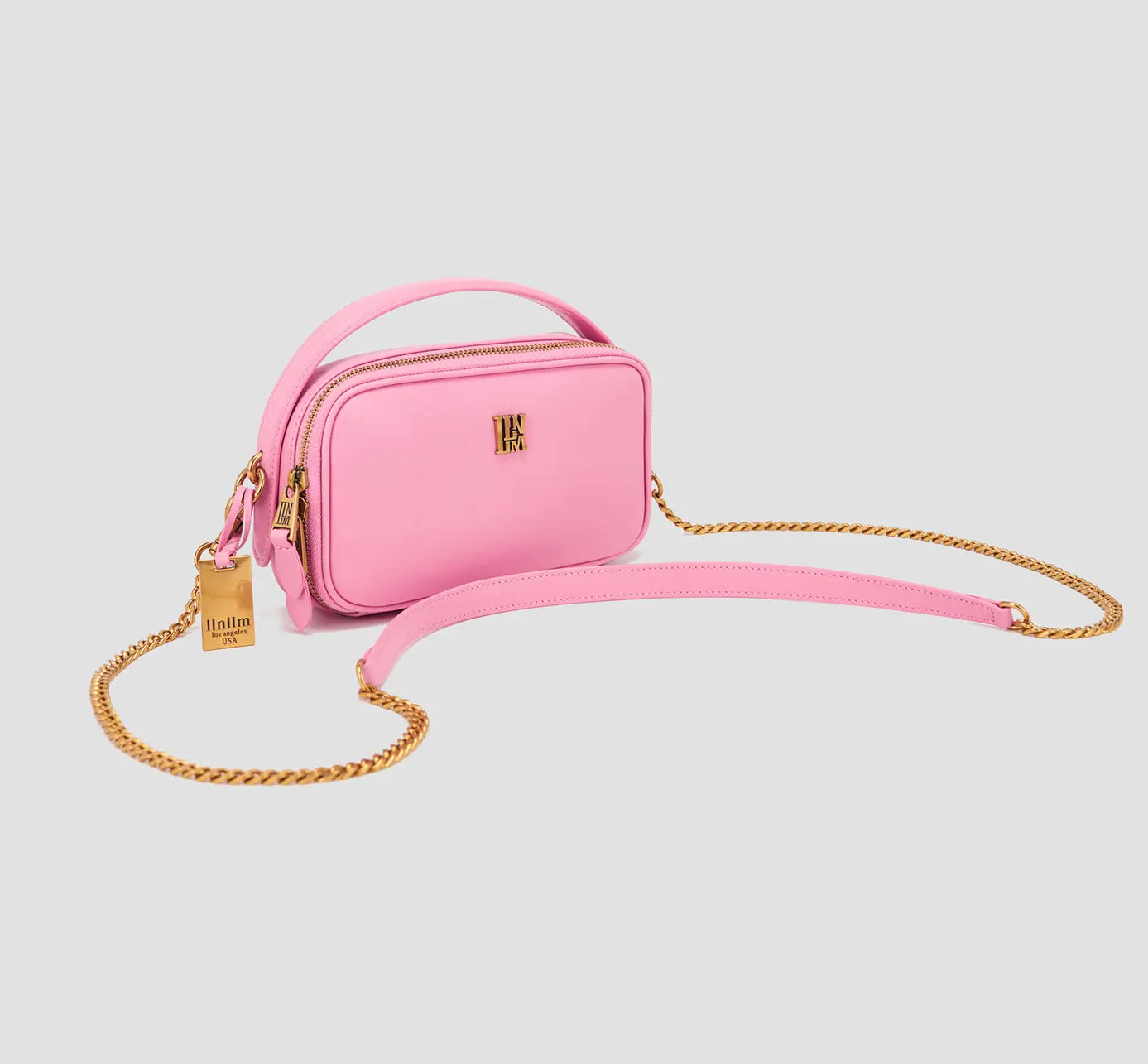 The angled view of chic pink crossbody handbag with gold chain strap – mini shoulder bag for women’s everyday style.