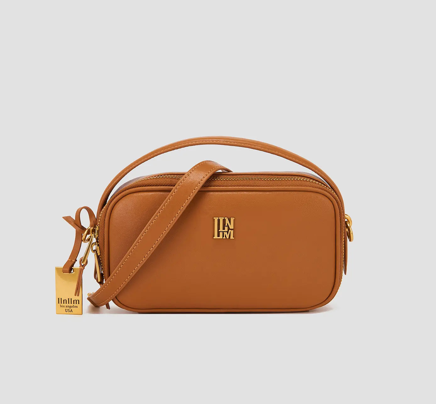 The front view of structured tan leather handbag – women's small shoulder bag with gold hardware, top handle crossbody purse.
