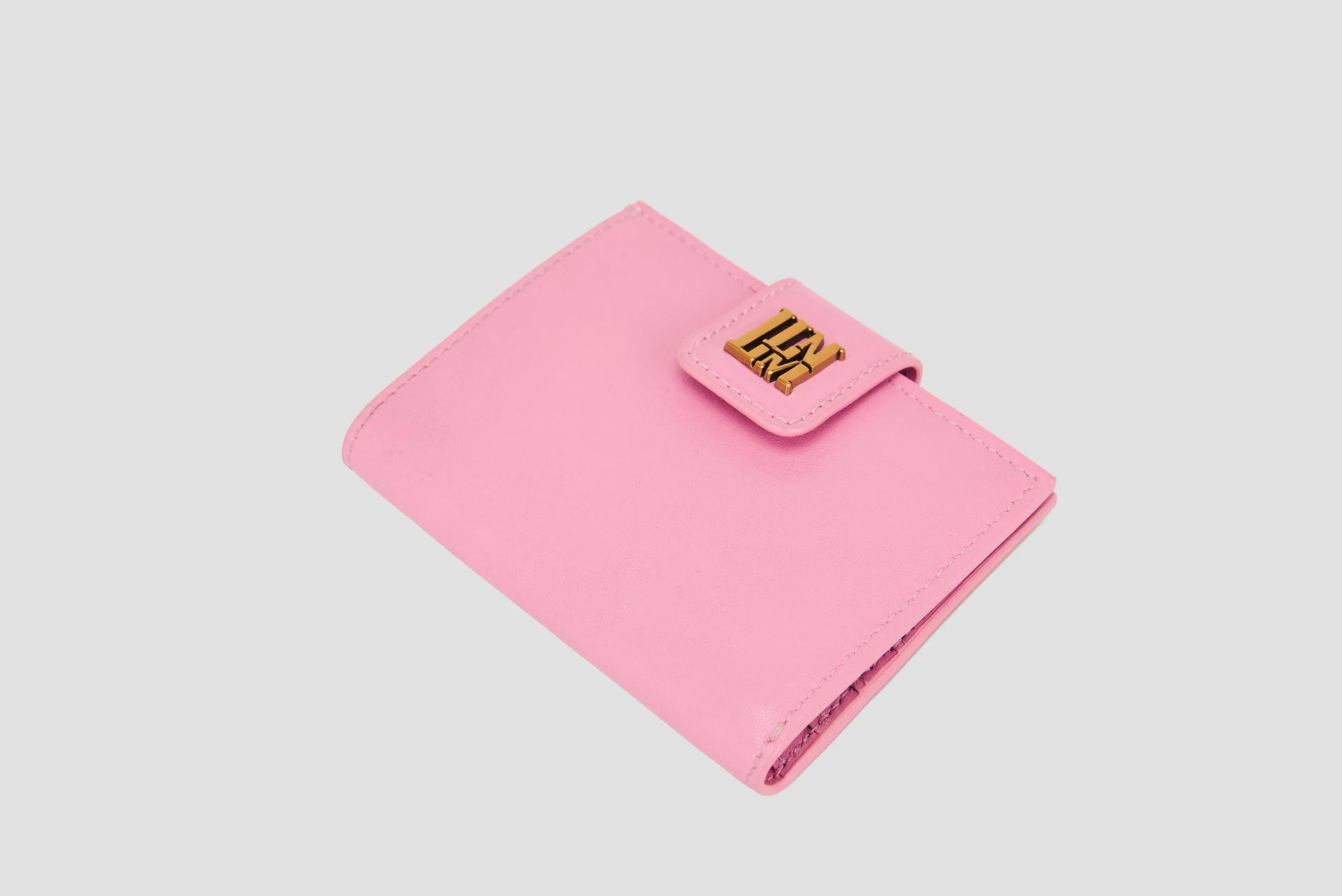 Angled view of pink llnllm wallet with gold logo snap closure, compact design.