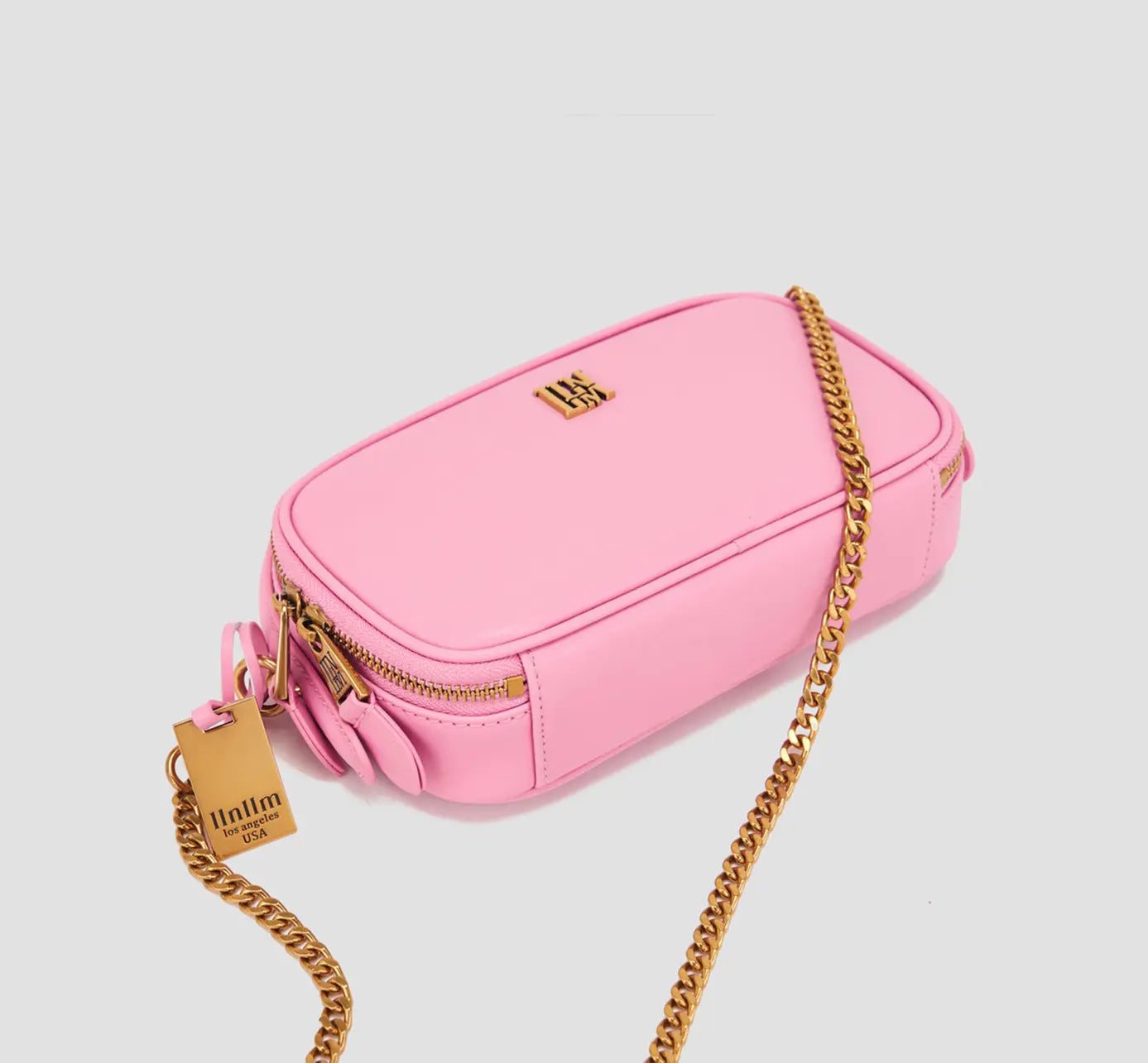 Elegant pink leather crossbody bag with zipper and gold chain detail – women’s statement purse.