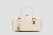 The front view of elegant white top handle handbag with gold hardware logo tag.