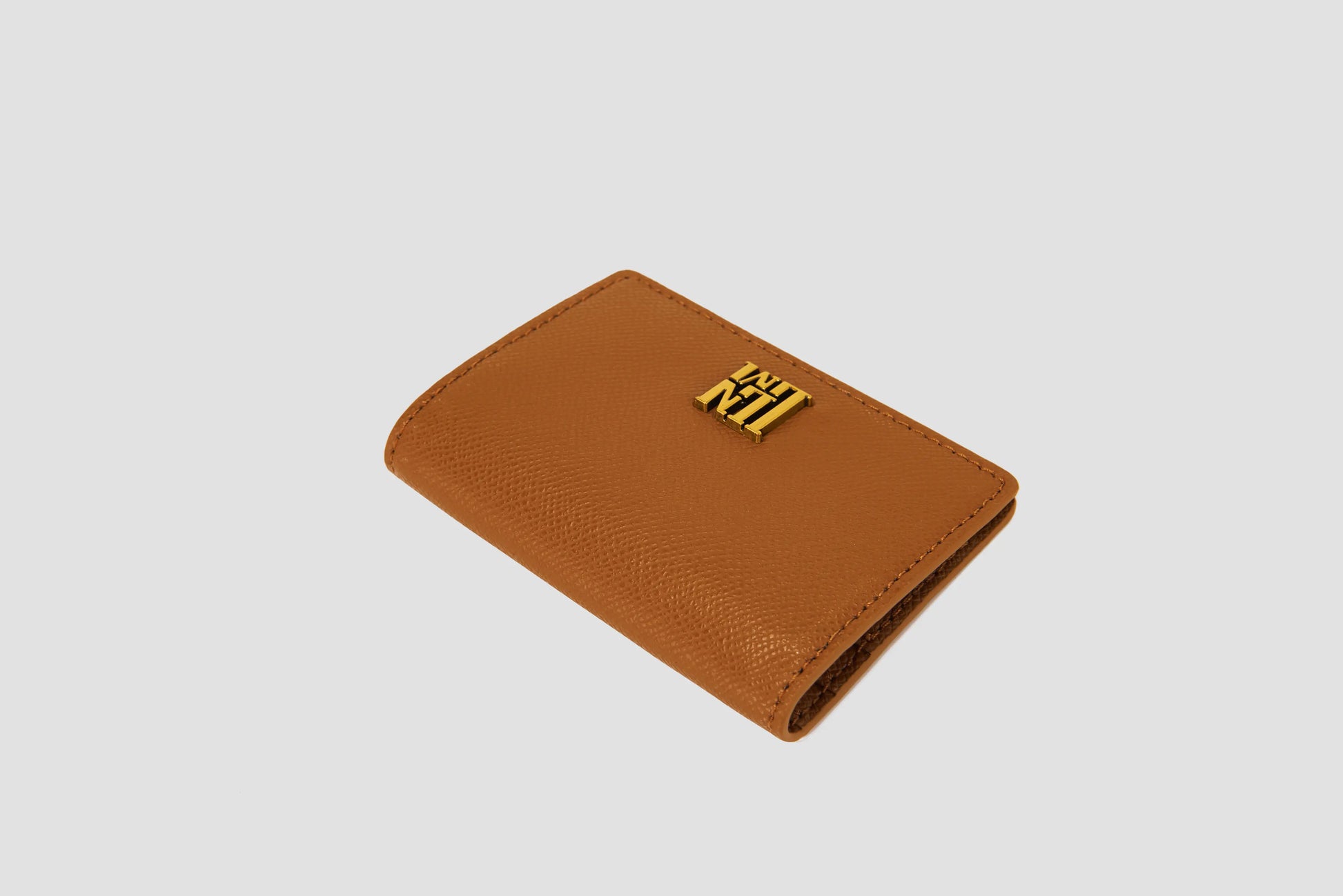Tan textured leather llnllm wallet with gold logo and magnetic closure.