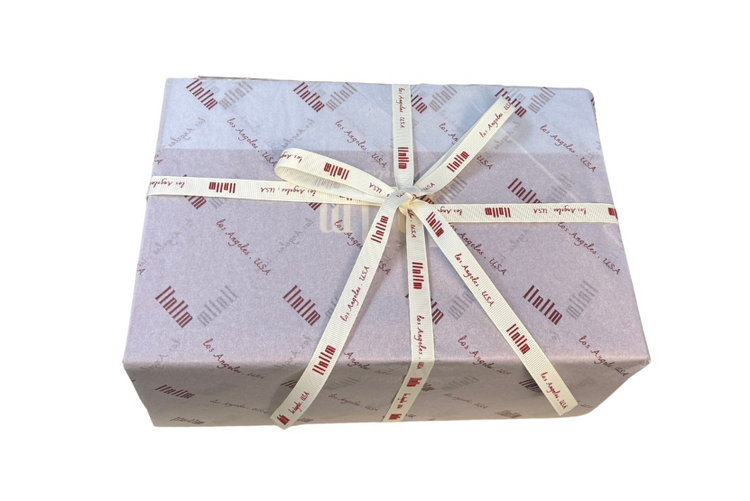 Handbag box wrapped in branded tissue paper and ribbon.